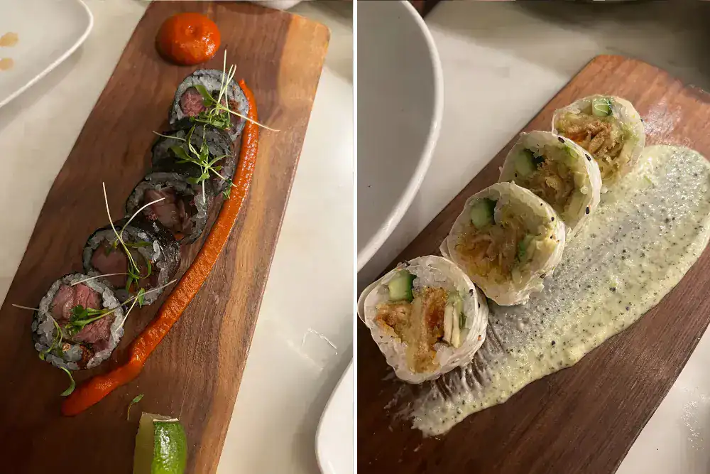 Two wooden boards with sushi rolls: the left board has dark seaweed-wrapped rolls with sauce and garnish, the right board has lighter rolls with sauce and cucumber filling.