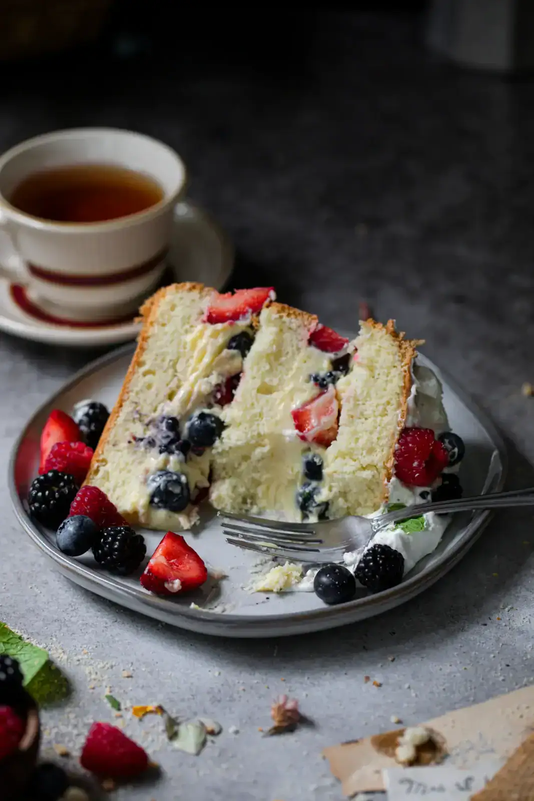 A plate of food with a fork and a cup of tea.